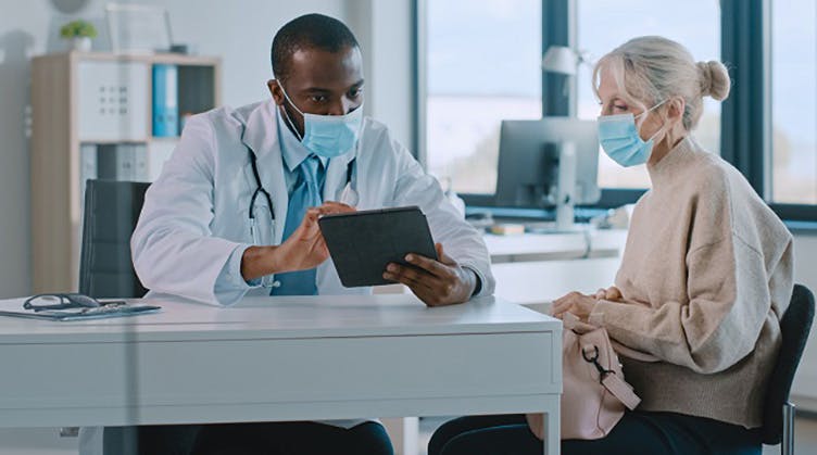 Doctor and patient reviewing information on tablet